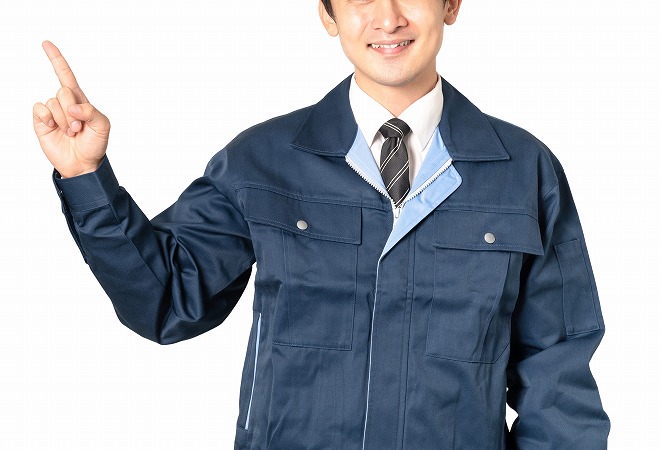 指を立てる作業服の男性